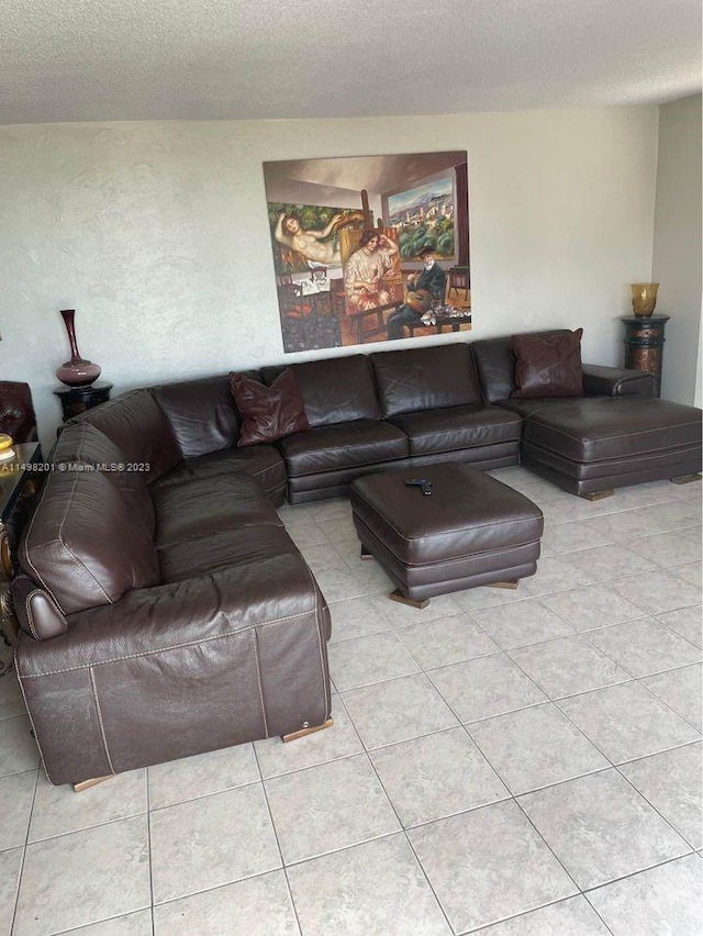 tiled living room featuring a textured ceiling