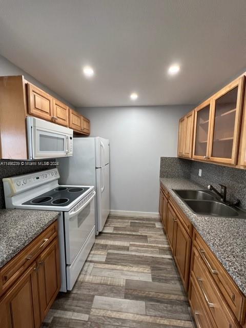 kitchen with white appliances, sink, backsplash, and hardwood / wood-style flooring