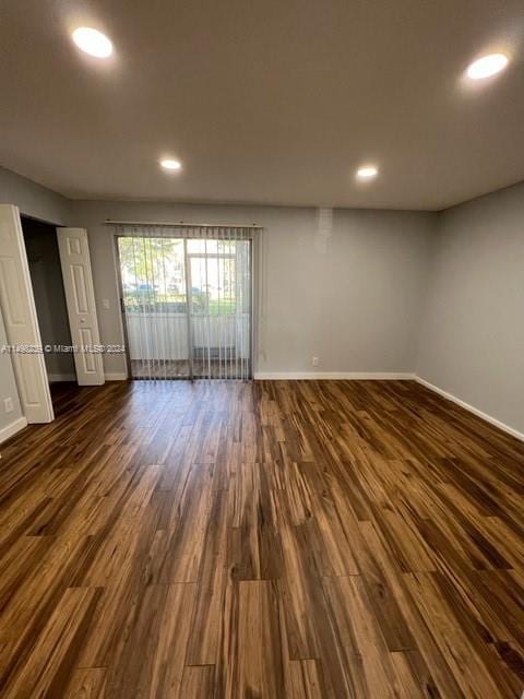 unfurnished room with dark hardwood / wood-style flooring