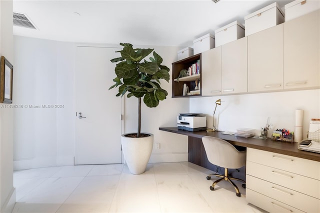 office with built in desk and light tile patterned floors