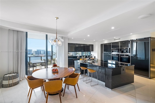 dining room with a water view, an inviting chandelier, and light tile patterned floors