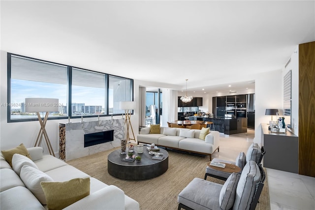 living room featuring a premium fireplace and a notable chandelier