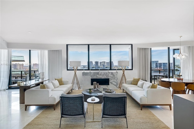 living room featuring an inviting chandelier, light tile patterned floors, and plenty of natural light