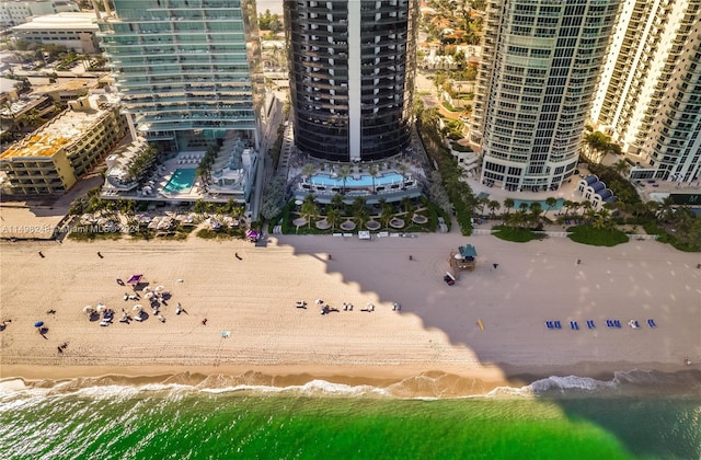 drone / aerial view featuring a beach view and a water view