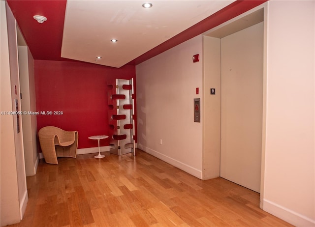 unfurnished room with baseboards, recessed lighting, and light wood-type flooring