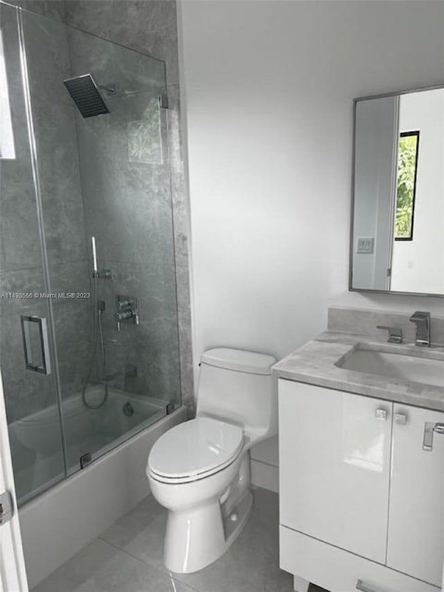 full bathroom with vanity, toilet, tile patterned flooring, and combined bath / shower with glass door