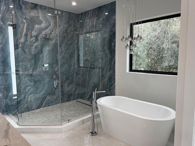 bathroom with shower with separate bathtub and a wealth of natural light