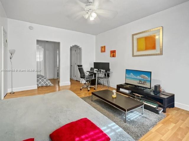 living room with wood-type flooring and ceiling fan