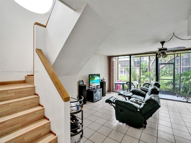 tiled living room featuring ceiling fan and a wall of windows