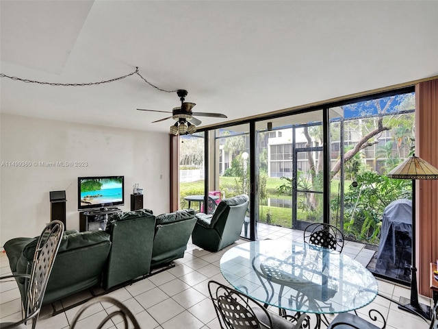 tiled living room with ceiling fan and a wall of windows