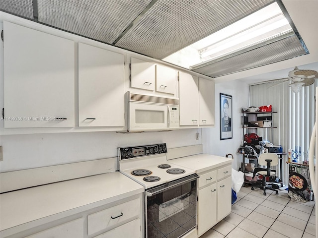 kitchen with white cabinetry, electric range, and light tile patterned floors