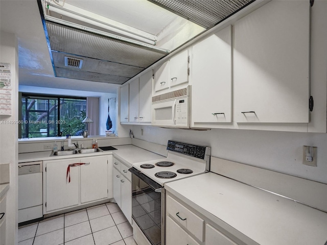 kitchen featuring light tile patterned floors, sink, white appliances, and white cabinets