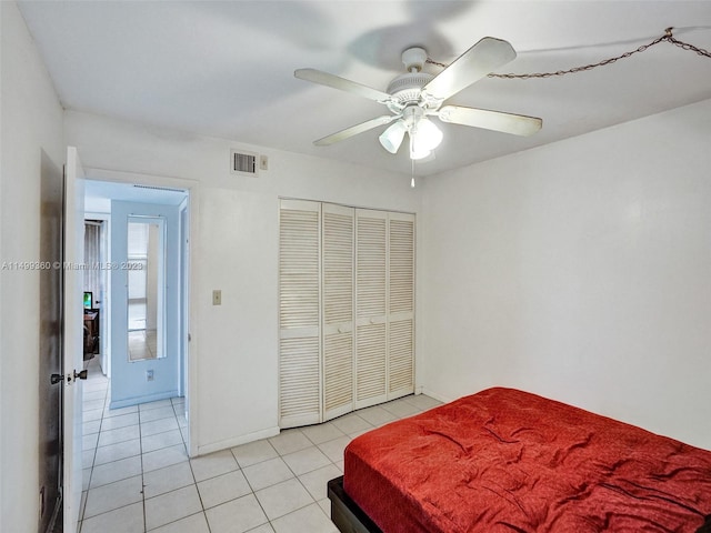 bedroom featuring ceiling fan, a closet, and light tile patterned flooring