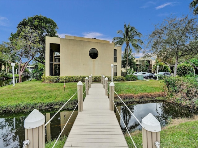 dock area featuring a water view and a lawn