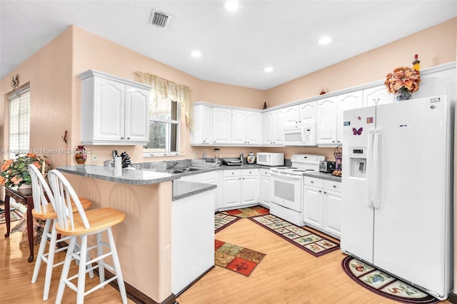 kitchen featuring white appliances, white cabinetry, and light wood-type flooring