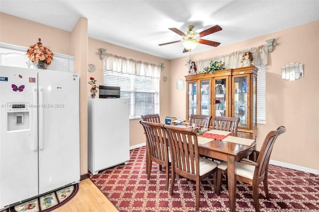 dining space with ceiling fan and light wood-type flooring