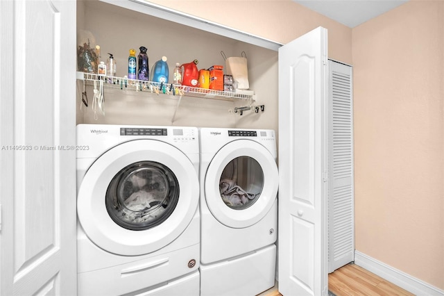 laundry area featuring washer and dryer and light hardwood / wood-style flooring