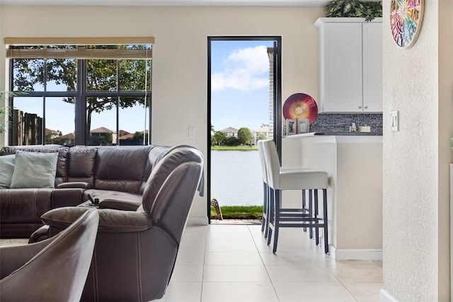 living room with light tile patterned flooring and a water view