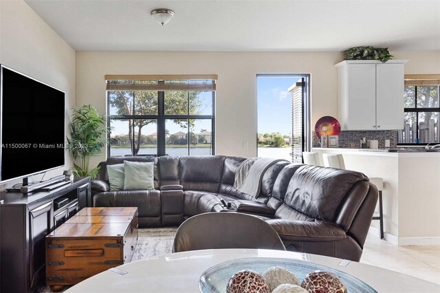 living room with a water view and light tile patterned floors