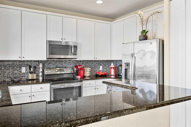 kitchen featuring backsplash, white cabinets, dark stone counters, and appliances with stainless steel finishes