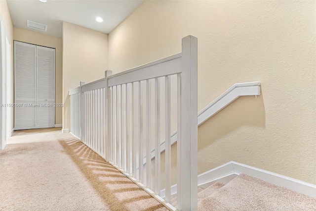 hall featuring carpet flooring