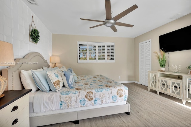 bedroom featuring light wood-type flooring, a closet, and ceiling fan