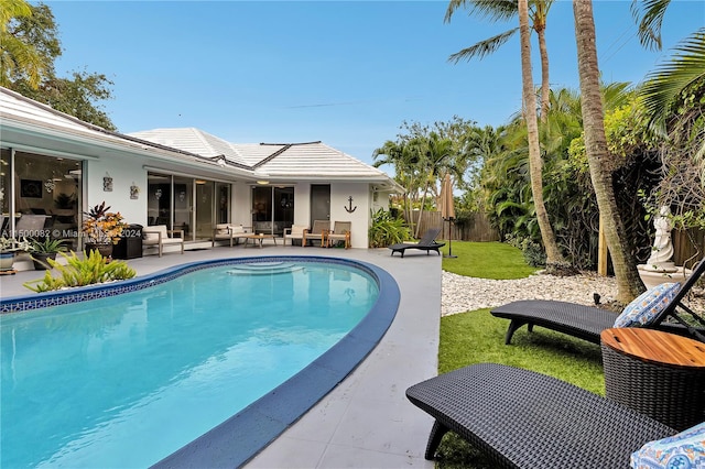 view of pool with a lawn, an outdoor living space, and a patio area