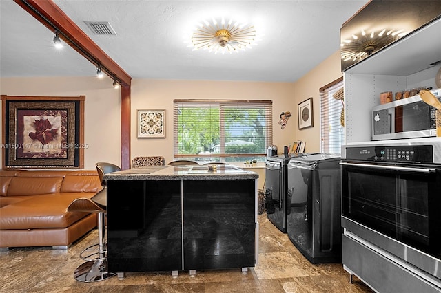 laundry area featuring washer and clothes dryer and rail lighting