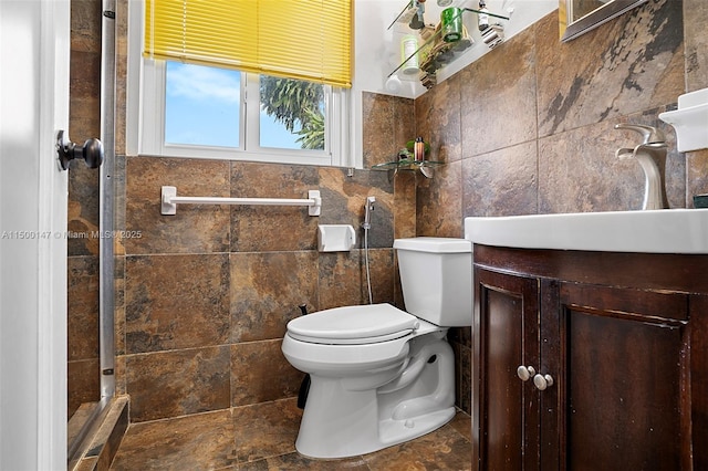 bathroom with tile walls, toilet, and vanity