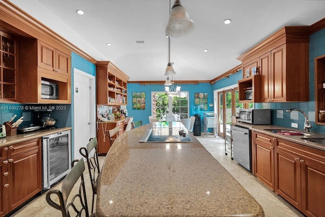 kitchen featuring stainless steel appliances, wine cooler, hanging light fixtures, and ornamental molding