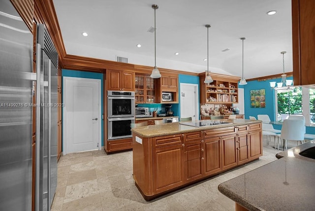 kitchen with light stone counters, crown molding, pendant lighting, a kitchen island, and appliances with stainless steel finishes