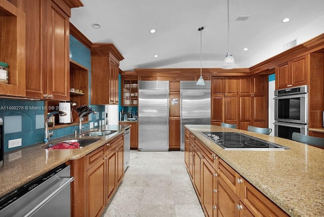 kitchen with light stone counters, pendant lighting, stainless steel appliances, and lofted ceiling