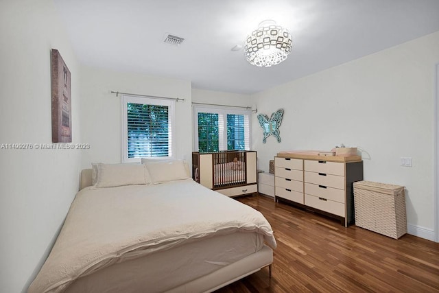 bedroom with dark hardwood / wood-style flooring