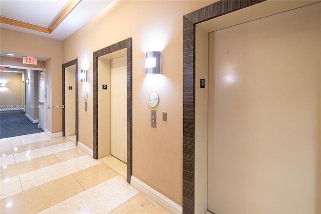 hall featuring light tile floors and elevator