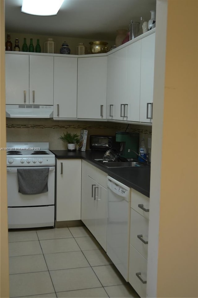 kitchen with white appliances, light tile patterned floors, and white cabinetry