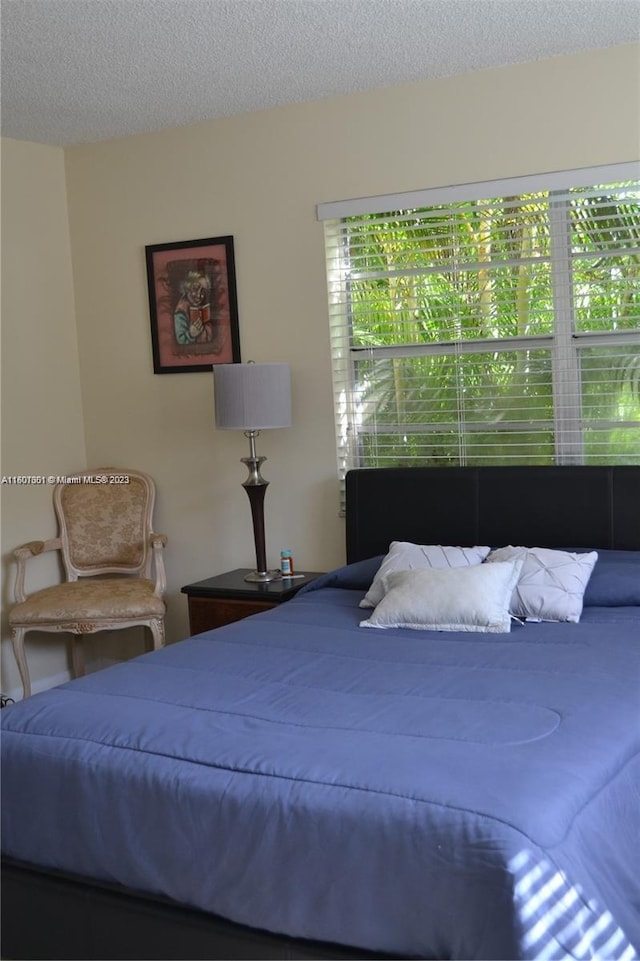 bedroom featuring a textured ceiling and multiple windows