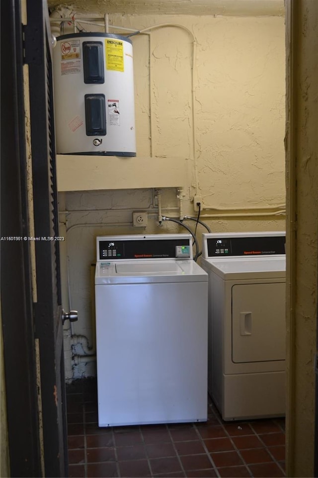 laundry area featuring water heater, tile patterned floors, and washer and clothes dryer