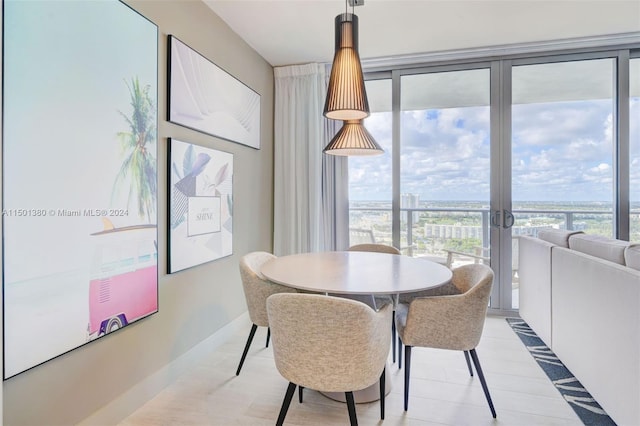 dining space with light hardwood / wood-style flooring, french doors, and floor to ceiling windows