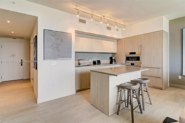 4010 S Ocean Dr Unit R2106, Hollywood, FL 33019 - kitchen with modern cabinets, visible vents, light brown cabinetry, and a kitchen bar