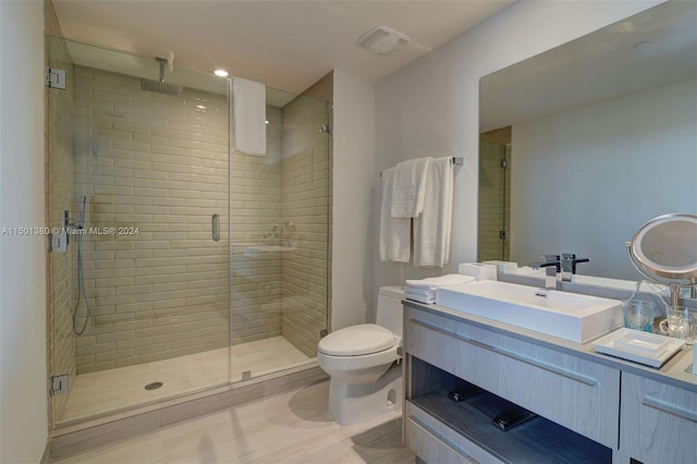 bathroom featuring a shower with door, toilet, and vanity