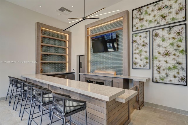 4010 S Ocean Dr Unit R2106, Hollywood, FL 33019 - kitchen with a kitchen breakfast bar, light stone countertops, baseboards, and visible vents