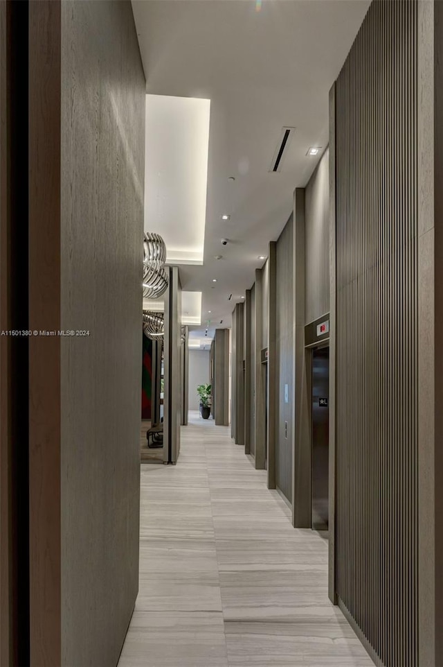 hall with elevator and light tile patterned floors