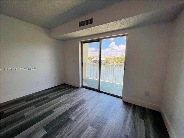 empty room featuring a textured ceiling and hardwood / wood-style flooring