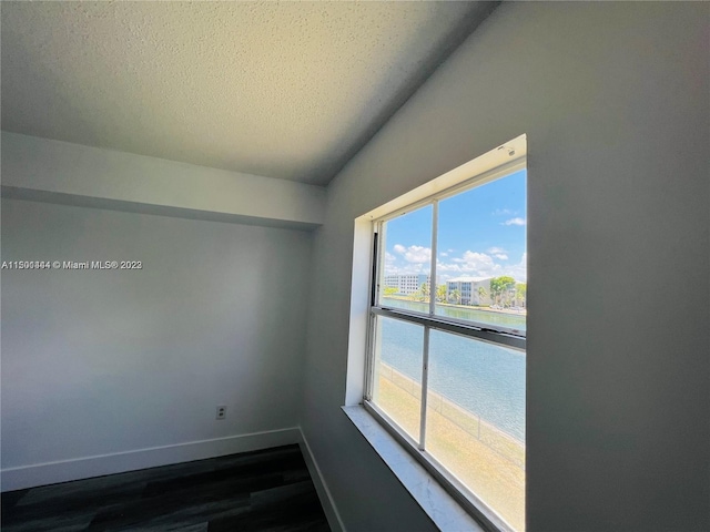 spare room featuring a textured ceiling and hardwood / wood-style flooring