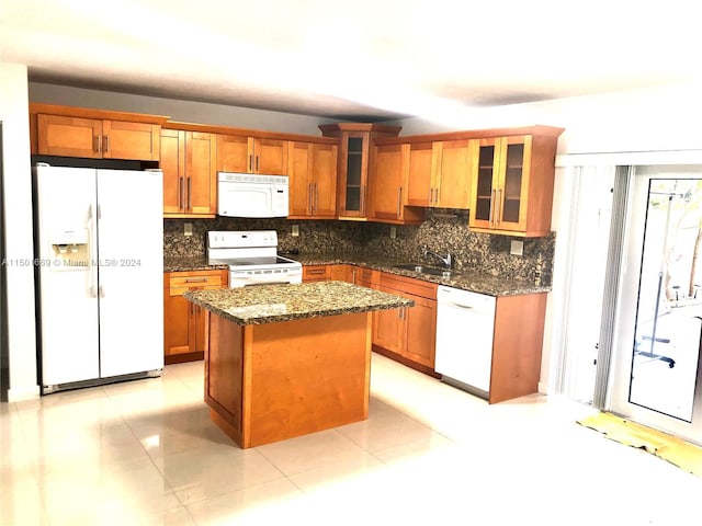 kitchen with light tile floors, a kitchen island, dark stone counters, tasteful backsplash, and white appliances