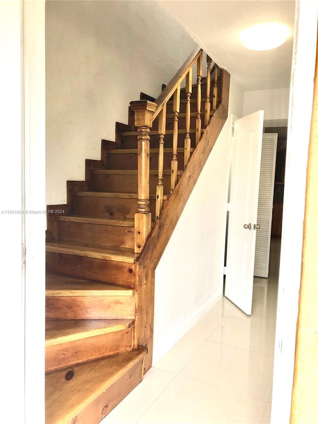 staircase featuring light tile flooring