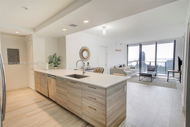 kitchen with a wall of windows, stainless steel dishwasher, sink, and light hardwood / wood-style flooring