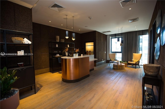 kitchen featuring decorative light fixtures, light hardwood / wood-style floors, and a center island