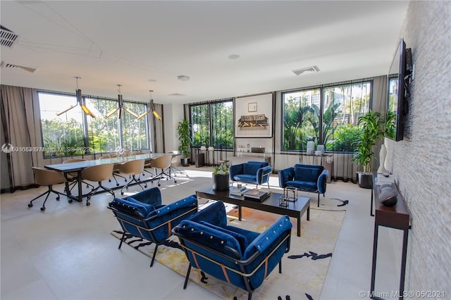 living room featuring plenty of natural light, light tile flooring, and a chandelier