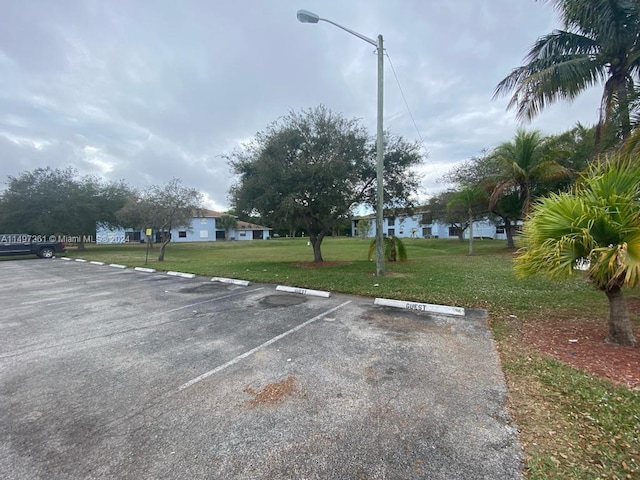 view of parking / parking lot featuring a lawn